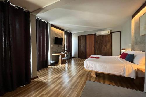 Schlafzimmer mit einem weißen Bett und Holzboden in der Unterkunft TANYA Baan Bon Doi in Ban San Ton Ko (1)