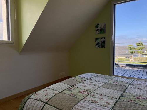 une chambre avec un lit et une grande fenêtre dans l'établissement 803 - Magnifique maison moderne située à Erquy disposant d'une piscine privative, à Erquy