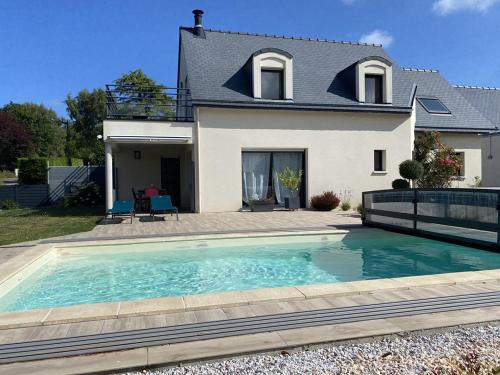 une maison avec une piscine devant une maison dans l'établissement 803 - Magnifique maison moderne située à Erquy disposant d'une piscine privative, à Erquy
