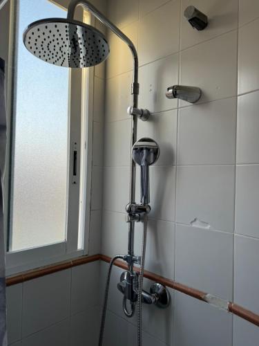 a shower with a shower head in a bathroom at Louie Louie Apartment Old Town in Tarragona
