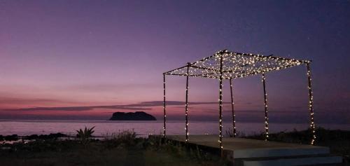 a wedding altar with lights on the beach at night at The Beach Resort & Residence - SHA Plus in Pathiu