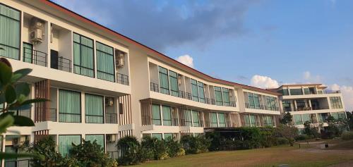 a large building with windows on the side of it at The Beach Resort & Residence - SHA Plus in Pathiu