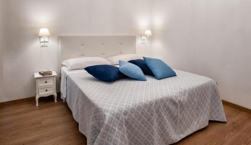 a bedroom with a bed with blue pillows on it at Baco B&B in Cagliari