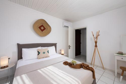 a bedroom with a large bed with white walls at Acroterra - Easy Living in Alyki
