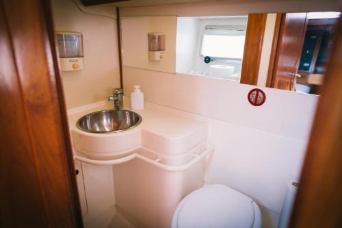 a small bathroom with a sink and a toilet at Sleep in boat in Catania