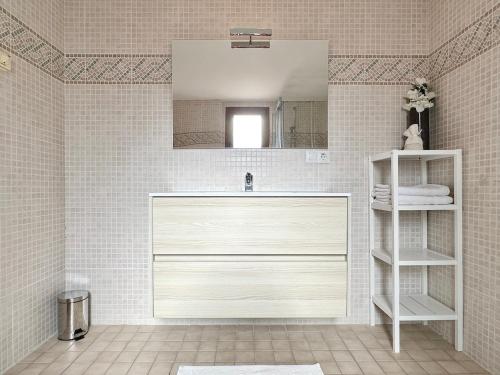 La salle de bains est pourvue d'un lavabo blanc et d'un miroir. dans l'établissement Bonito Apartamento Con Piscina y Jacuzzi, à L'Alfàs del Pi