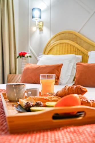 a table with a tray of food on a bed at Eden Suite Paris la Defense in Courbevoie