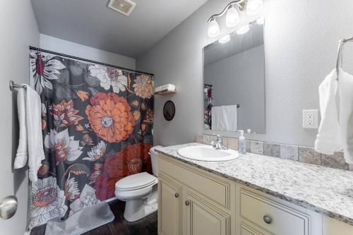 a bathroom with a sink and a toilet and a shower curtain at Modern Home 10 minutes from Dickson St & U of A in Fayetteville