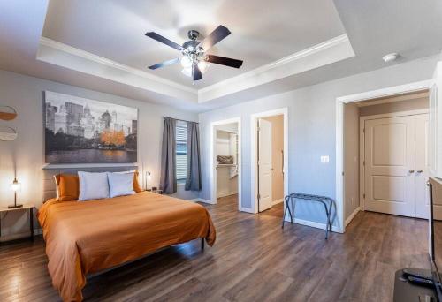 a bedroom with a bed and a ceiling fan at Modern Home 10 minutes from Dickson St & U of A in Fayetteville