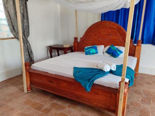 1 dormitorio con cama con dosel y toallas. en EAST SANDBANK apartment eco-friendly Nungwi airport road, en Nungwi