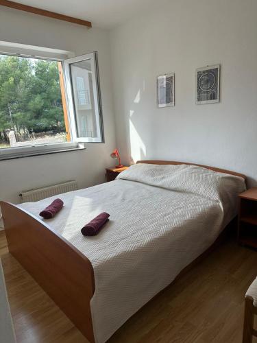 a bedroom with a bed with two purple pillows on it at Apartments Šimić in Zavala