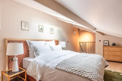 a bedroom with a large white bed and a dresser at Maison La Bohème Montmartre - Studios & Apartments in Paris