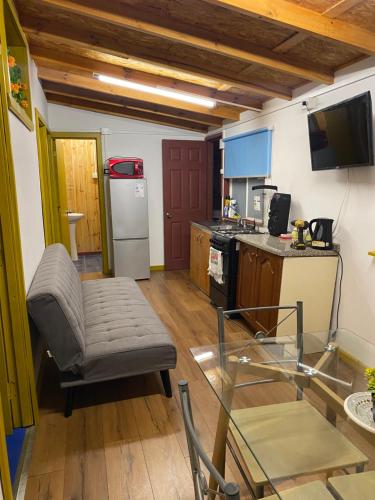 a living room with a couch and a kitchen at Comodo departamento in Puerto Montt