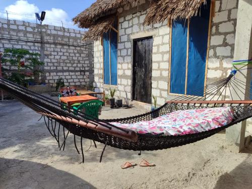 a hammock sitting in front of a house at EAST SANDBANK apartment eco-friendly Nungwi airport road in Nungwi