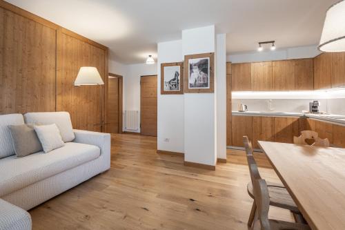 a living room with a white couch and a table at Chalet Falorie in Cortina dʼAmpezzo