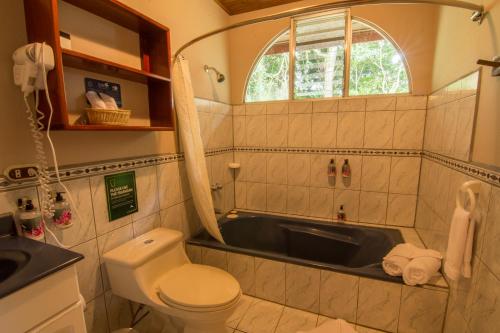 a bathroom with a sink and a toilet and a tub at Cala Lodge in Monteverde Costa Rica