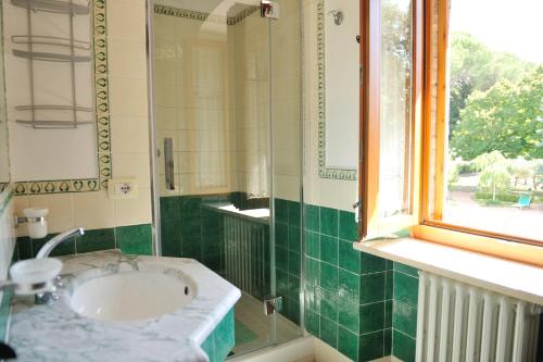 Un baño con lavabo y ventana. en Villa Colombella - Homelike Villas, en Perugia
