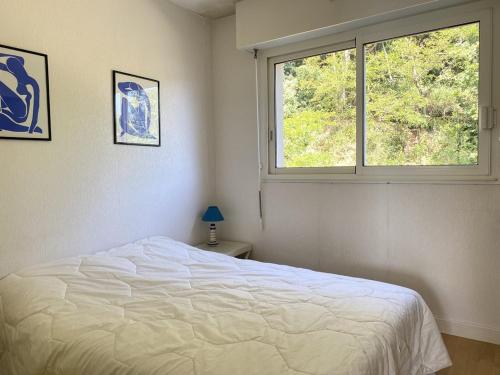 une chambre avec un lit blanc et une fenêtre dans l'établissement 500 - T2 avec balcon vue mer et proche du port, à Erquy