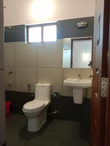 a bathroom with a toilet and a sink at Casa Branca Retreat in Varkala