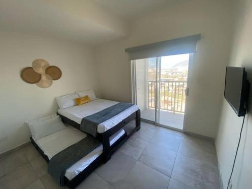 a small bedroom with a bed and a balcony at Bonito departamento en zona centrika in Monterrey