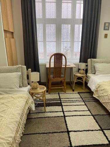 a bedroom with two beds and a table and a window at Lennon in Vinkovci