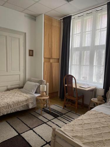 a bedroom with two beds and a table and a chair at Lennon in Vinkovci