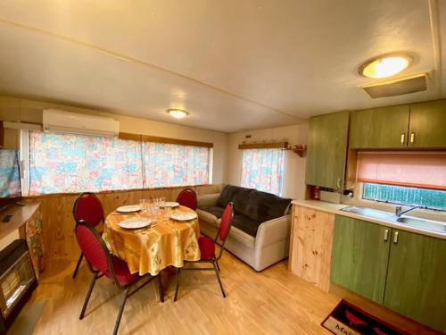 une cuisine avec une table et des chaises rouges dans une pièce dans l'établissement impasse des Terres Fortes, à Romorantin-Lanthenay
