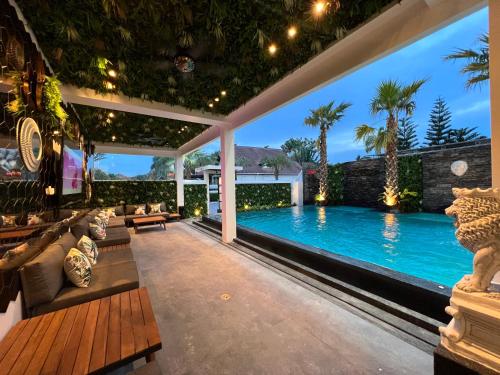an outdoor living room with a swimming pool and a patio at NEW 2022 Grand Deluxe ART Pool Villa in Jomtien Beach
