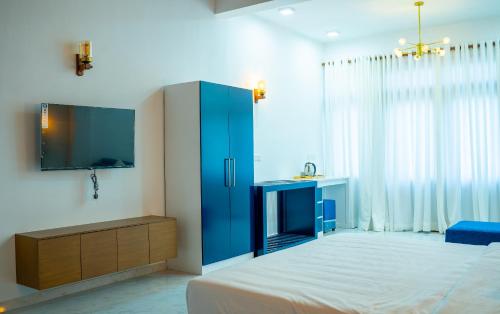 a bedroom with a blue cabinet and a tv at Piyum Villa Kosgoda in Kosgoda