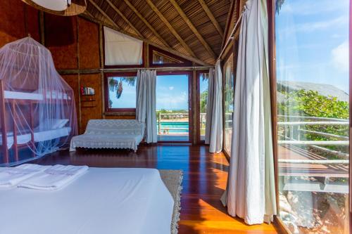 a bedroom with a bed and a large window at Ilha dos Poldros in Araioses