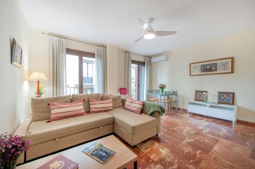 ein Wohnzimmer mit einem Sofa und einem Tisch in der Unterkunft Ispal Apartment & Parking Seville Historic Center vutse06601 in Sevilla