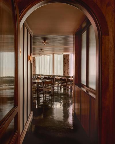 an archway in a room with a table and chairs at Hotel Lucine in Galveston