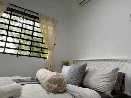 a bedroom with a white bed with a window at Comfy 3BR Apartment Our Homestay Pusing Batu Gajah in Pusing