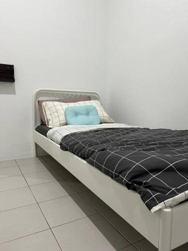 a bed with a blue pillow on top of it at Pusing Kampung Affordable Homestay in Pusing