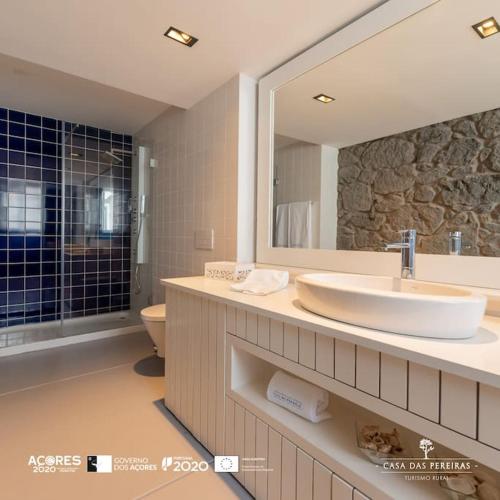 Calheta de Nesquim的住宿－T2 Casa das Pereiras，一间带水槽、卫生间和镜子的浴室