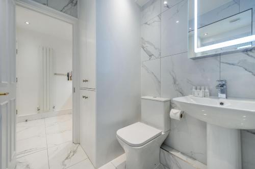 a white bathroom with a toilet and a sink at The Fairytale - Fitzrovia - by Frankie Says in London