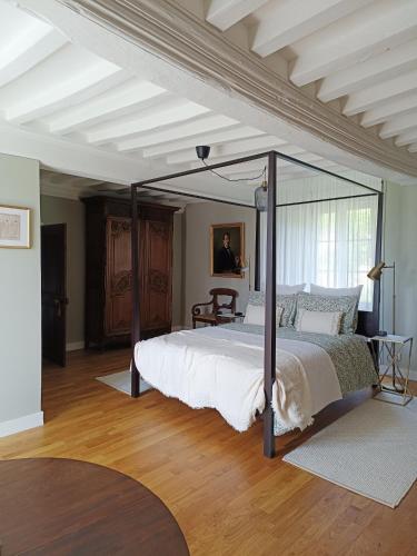 a bedroom with a large bed with a canopy at La Thérèsienne in Pleines-Oeuvres