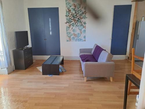 sala de estar con sofá y TV en Appartement centre ville de la mure, en La Mure