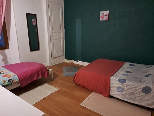 1 dormitorio con cama y pared verde en Appartement centre ville de la mure, en La Mure
