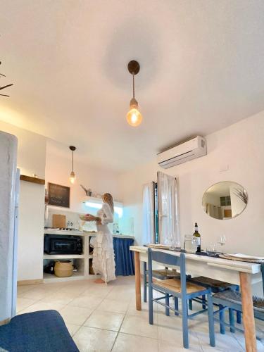 a woman standing in a kitchen with a table at Boutique Apartments Ibiscus in Santa Maria