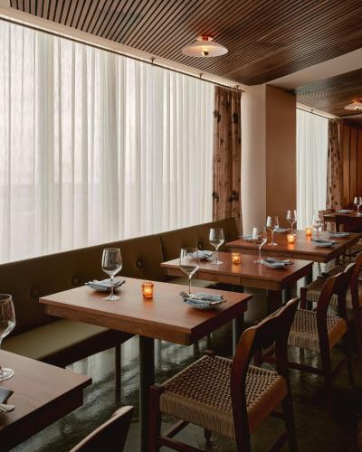 a row of tables in a restaurant with wine glasses at Hotel Lucine in Galveston