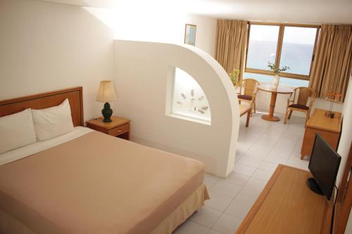 a hotel room with a bed and a living room at Hippocampus Vacation Club in Pampatar