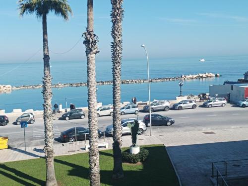 a parking lot with cars parked next to the ocean at Il sottano borgo antico in Bari