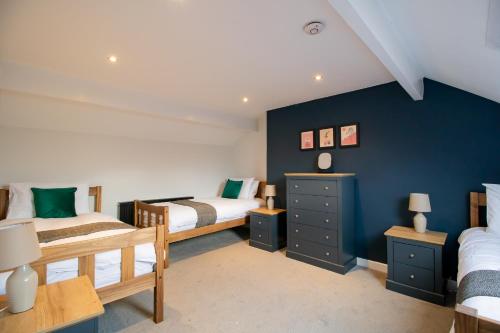 1 dormitorio con 2 camas y pared azul en Charming House - Perfect For Long Stays en Bishop Auckland