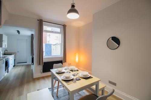 sala de estar con mesa y cocina en Charming House - Perfect For Long Stays en Bishop Auckland