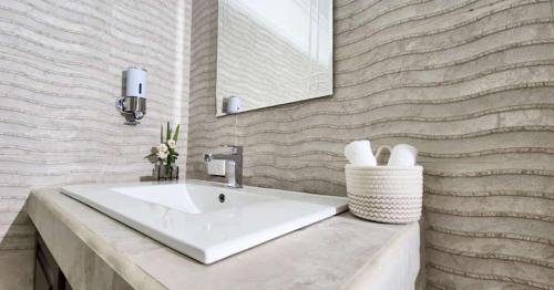 a bathroom with a white sink and a mirror at Hotel Río Peje 