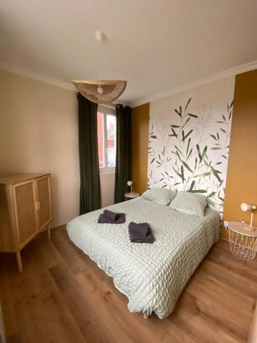 una camera da letto con un letto con due asciugamani sopra di L'évasion Havraise a Le Havre