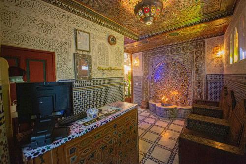 Una televisión o centro de entretenimiento en Riad Fes Iline