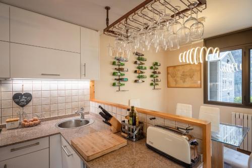 a kitchen with a sink and a counter with wine bottles at UNIQUE 57m2 Terraza BBQ vista mágica1-0 in Canillo