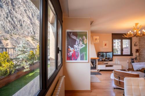 uma sala de estar com uma grande janela e um sofá em UNIQUE 57m2 Terraza BBQ magica vista Quer em Canillo